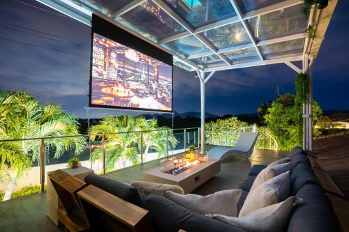 a living room with a couch and a large screen at Kira Japandi Escape with Sauna & Rooftop cinema in Hua Hin