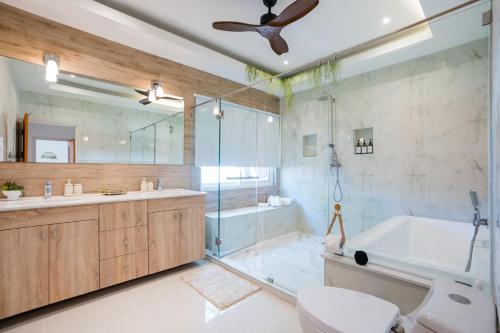a bathroom with a tub and a toilet and a shower at Kira Japandi Escape with Sauna & Rooftop cinema in Hua Hin