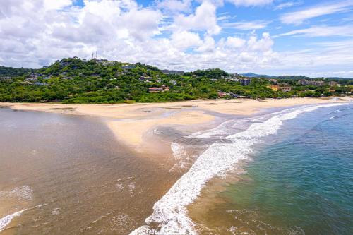 an aerial view of a beach with the ocean at Sunrise 1- 3 Bedroom Poolside Condo in Tamarindo
