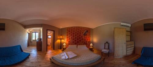 a bedroom with a bed and two blue chairs at Agriturismo Quartuccio in Oricola