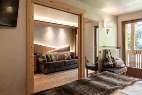 a bedroom with a sliding glass door leading to a couch at Cerana Relax Hotel in Madonna di Campiglio