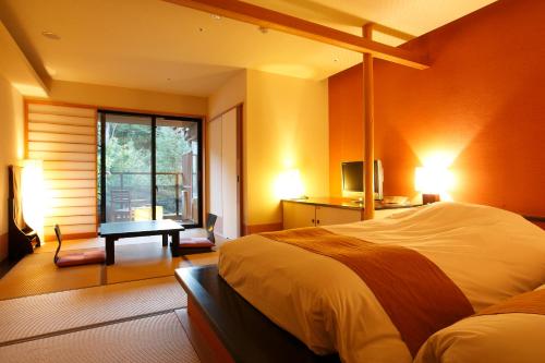 een slaapkamer met een bed, een bureau en een raam bij Setsugetsuka in Hakone