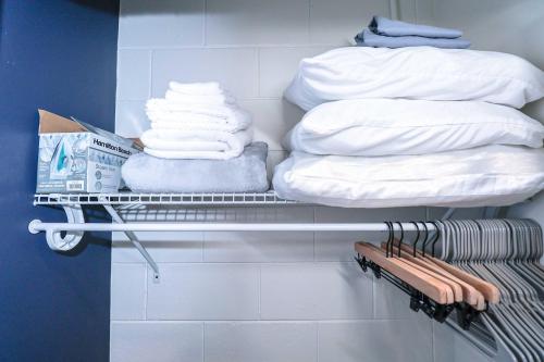 オーランドにあるNEW5 APT NrUCF PETSOK PRIVATE patioENTRY LAUNDRYの部屋の棚にタオルを積み重ねる