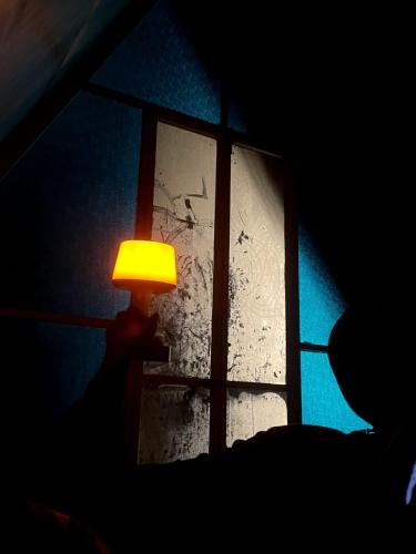 a person holding a lamp in front of a window at midwaytrip in Suryanelli