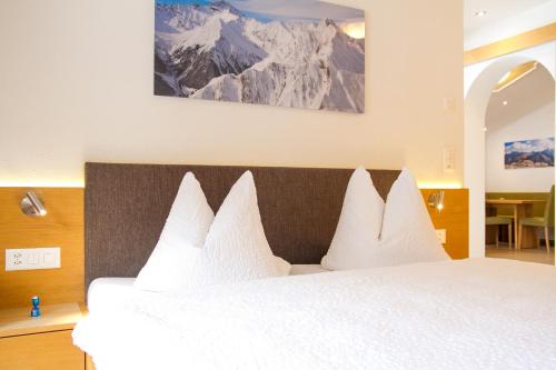 a bedroom with a large bed with white pillows at Apart Prieth Samnaun in Samnaun