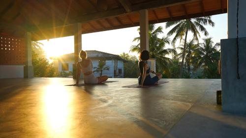 a group of three women sitting on the floor in a yoga class at OMA Hikkaduwa in Hikkaduwa