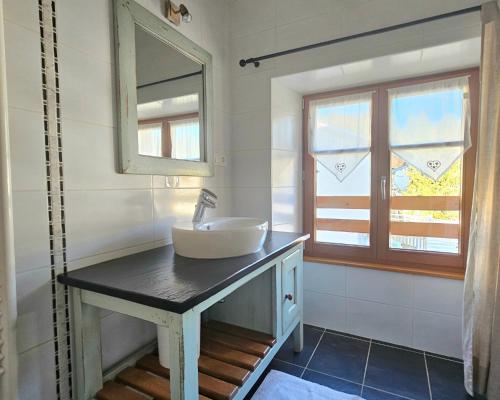 une salle de bain avec un lavabo et un miroir dans l'établissement Maison au cœur de la forêt, à Saint-Laurent-en-Grandvaux