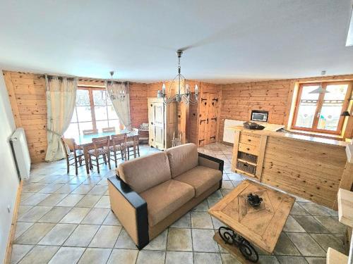 un salon avec un canapé et une table dans l'établissement Maison au cœur de la forêt, à Saint-Laurent-en-Grandvaux