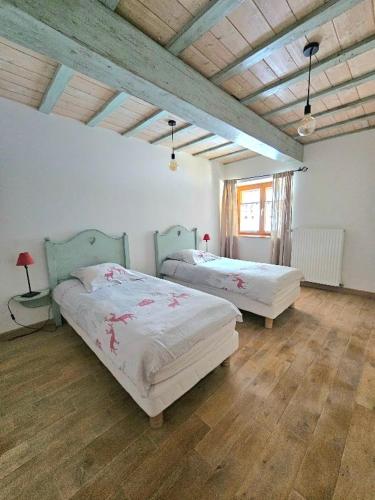 une chambre avec deux lits et un parquet dans l'établissement Maison au cœur de la forêt, à Saint-Laurent-en-Grandvaux