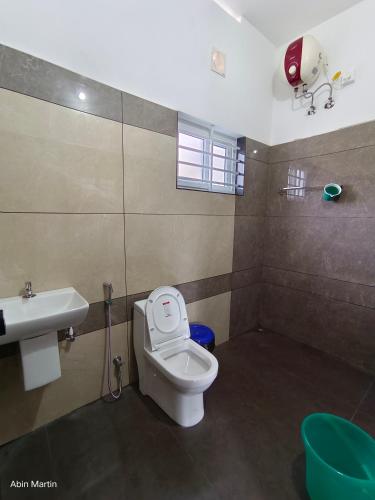 a bathroom with a toilet and a sink at Accadio Residency in Kattappana