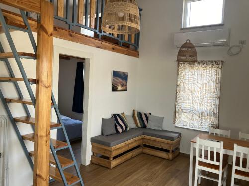 a living room with a bunk bed and a ladder at בריזה במדבר in Idan