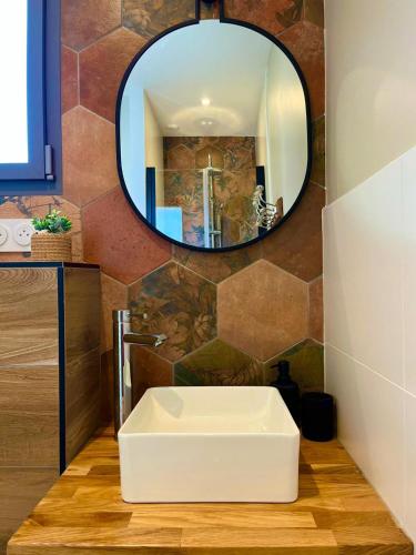 une salle de bain avec un lavabo blanc et un miroir dans l'établissement Sun Oasis Le Cocon, à Bretignolles-sur-Mer