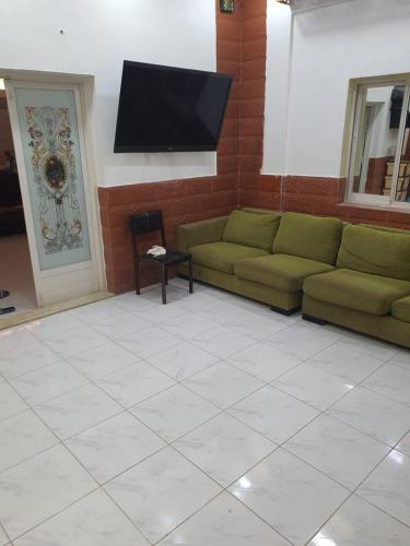 a living room with a couch and a flat screen tv at Furnished Bedroom with beside or out side bathroom in Sharjah