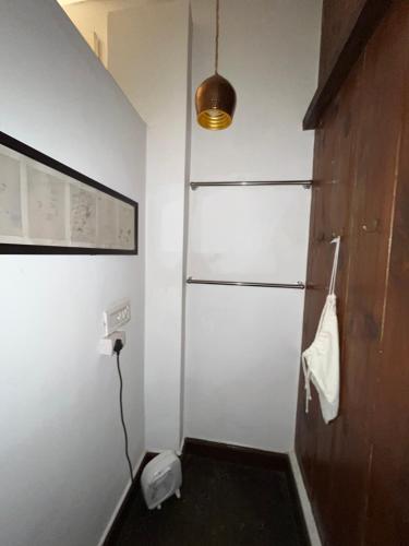 a bathroom with a shower with a white wall at Samira's Birds & Butterflies Park-Spashram Ganga Beach Retreat in Rishīkesh