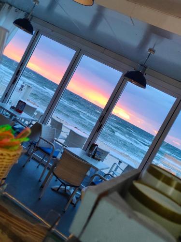 a view of the ocean from a room with windows at Villa Martini in Międzyzdroje