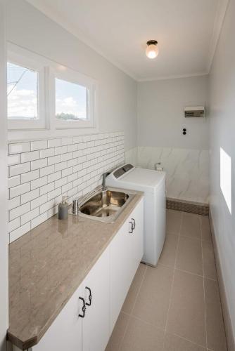 a white kitchen with a sink and a window at Diamond Hills Campbell Town in Campbell Town