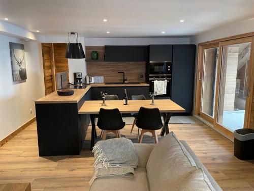 une cuisine et un salon avec une table et un canapé dans l'établissement VAUJANYLOCATIONS - Flocon 1, à Vaujany