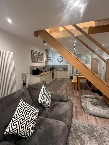 a living room with a couch and a kitchen at Abbys Cottage in Windermere