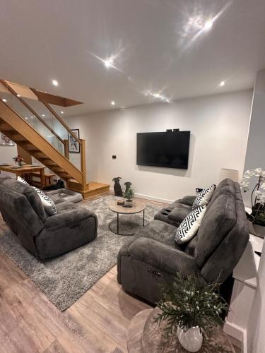 a living room with a couch and a flat screen tv at Abbys Cottage in Windermere