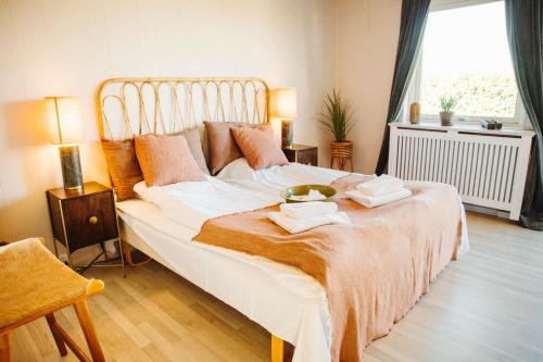 a bedroom with a large bed with towels on it at The Falcon Hotel in Allinge
