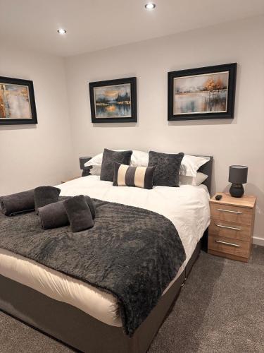 a bedroom with a large bed and a night stand at Abbys Cottage in Windermere