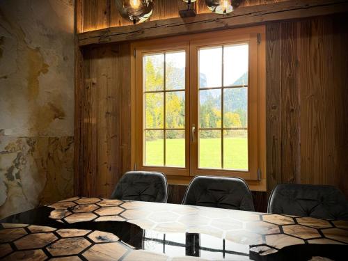 a room with a table and chairs and a window at Chalet Monjeri, modern und einzigartig in Kandersteg