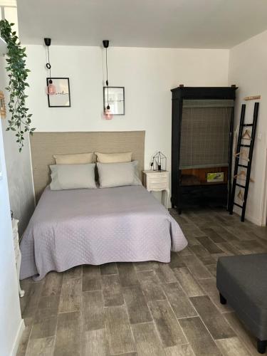 une chambre avec un grand lit et une chaise dans l'établissement L'appartement de Gaston, à Les Sablettes