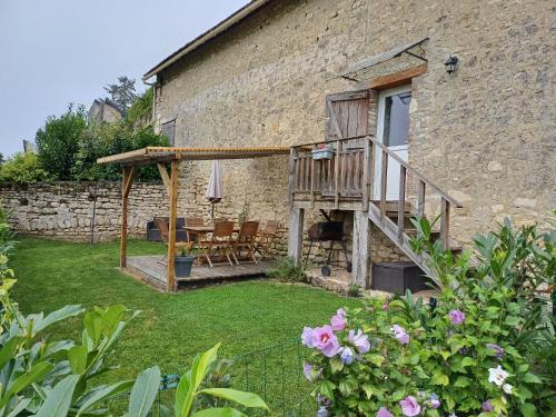 a house with a deck and a table and chairs at La maison du colombophile in Neuville-sur-Ailette