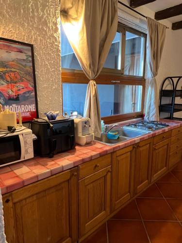 a kitchen counter with a microwave and a window at Panorama in Someraro