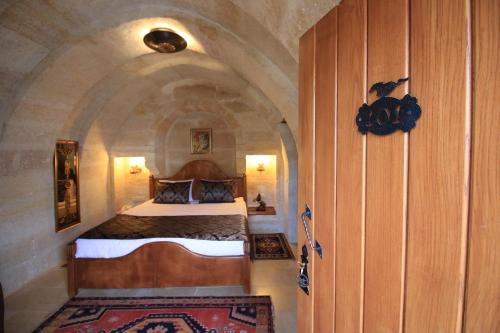 1 dormitorio con 1 cama en una habitación con un arco en Georgios Cave Cappadocia, en Ürgüp