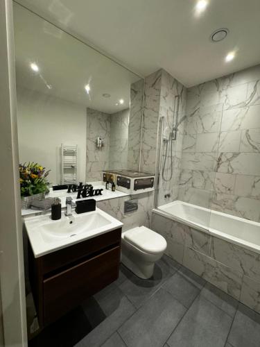 a bathroom with a sink and a toilet and a bath tub at Quartz manor in Manchester