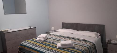 a bedroom with a bed with two towels on it at Harmony in Torre Archirafi
