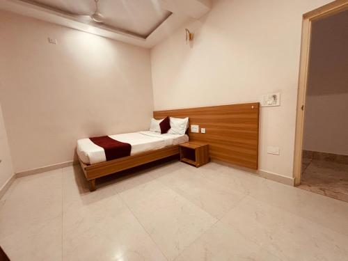 a small bedroom with a bed with a wooden headboard at Seema Palace Inn 1 km from Railwaystaion in Mysore