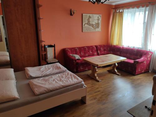 a living room with a red couch and a table at Apartament z widokiem na port & in Świnoujście