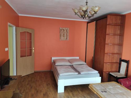 a bedroom with orange walls and a bed in it at Apartament z widokiem na port & in Świnoujście