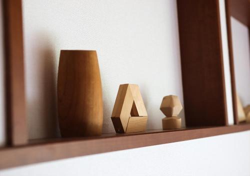 a shelf with two wooden vases and a mirror at 茂平の宿 in Yoro