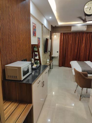a room with a microwave on a counter with a bed at Nestle Luxury Homes 1 in Lucknow