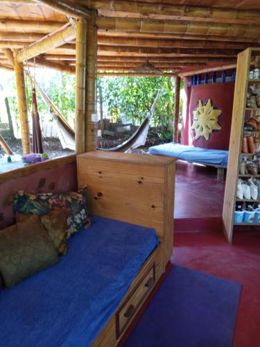 Zimmer mit einem Bett und einer Hängematte. in der Unterkunft Casa de bambu e garrafas no litoral de Serra Grande in Uruçuca