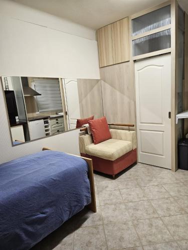 une chambre avec un lit, un canapé et une chaise dans l'établissement studio Chêne, à Bezons