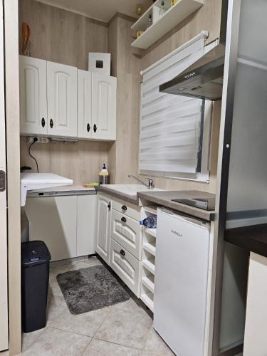 une cuisine avec des armoires blanches et un évier dans l'établissement studio Chêne, à Bezons