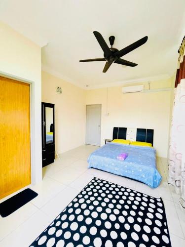 une chambre avec un lit et un ventilateur de plafond dans l'établissement D Corner Islam Homestay, à Kuala Kangsar