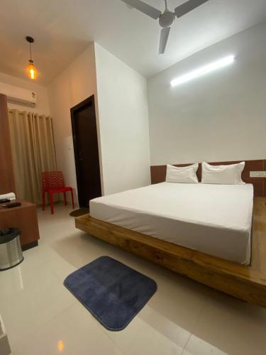 a bedroom with a white bed with a blue rug at Lake Land Guest House in Kolkata
