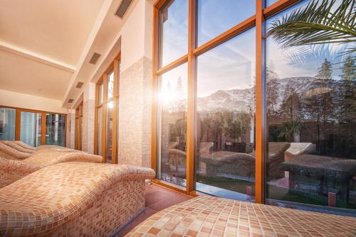a bedroom with a large window with a mountain view at Ski & Wellness Residence Družba in Demanovska Dolina