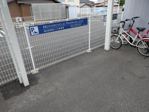 two bikes are parked next to a fence at Amistad Hotel in Matsuura