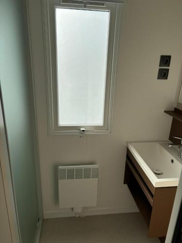 une salle de bain avec un lavabo et une fenêtre dans l'établissement Camping les dunes 5 étoiles - Mobil Home 6 personnes, à Torreilles