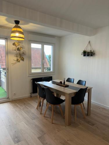une salle à manger avec une table et des chaises en bois dans l'établissement Appartement proche gare avec terrasse, à Besançon