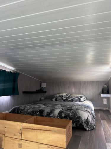 - une chambre avec un grand lit et un cadre de lit en bois dans l'établissement La tiny house Luna, à Villefranche-de-Longchat