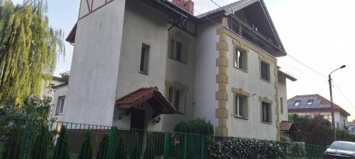un bâtiment blanc avec une clôture devant dans l'établissement Apartament n &, à Świnoujście