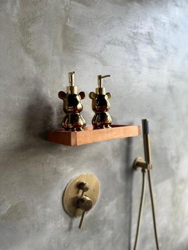two brass cows on a shelf on a wall at La Varuna Kintamani in Kintamani