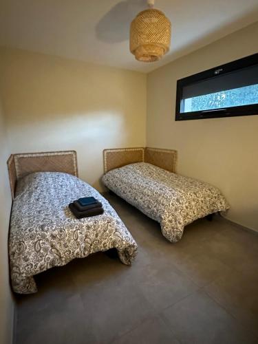 deux lits côte à côte dans une pièce dans l'établissement Maison T3 dans un village calme, à Saint-Mitre-les-Remparts